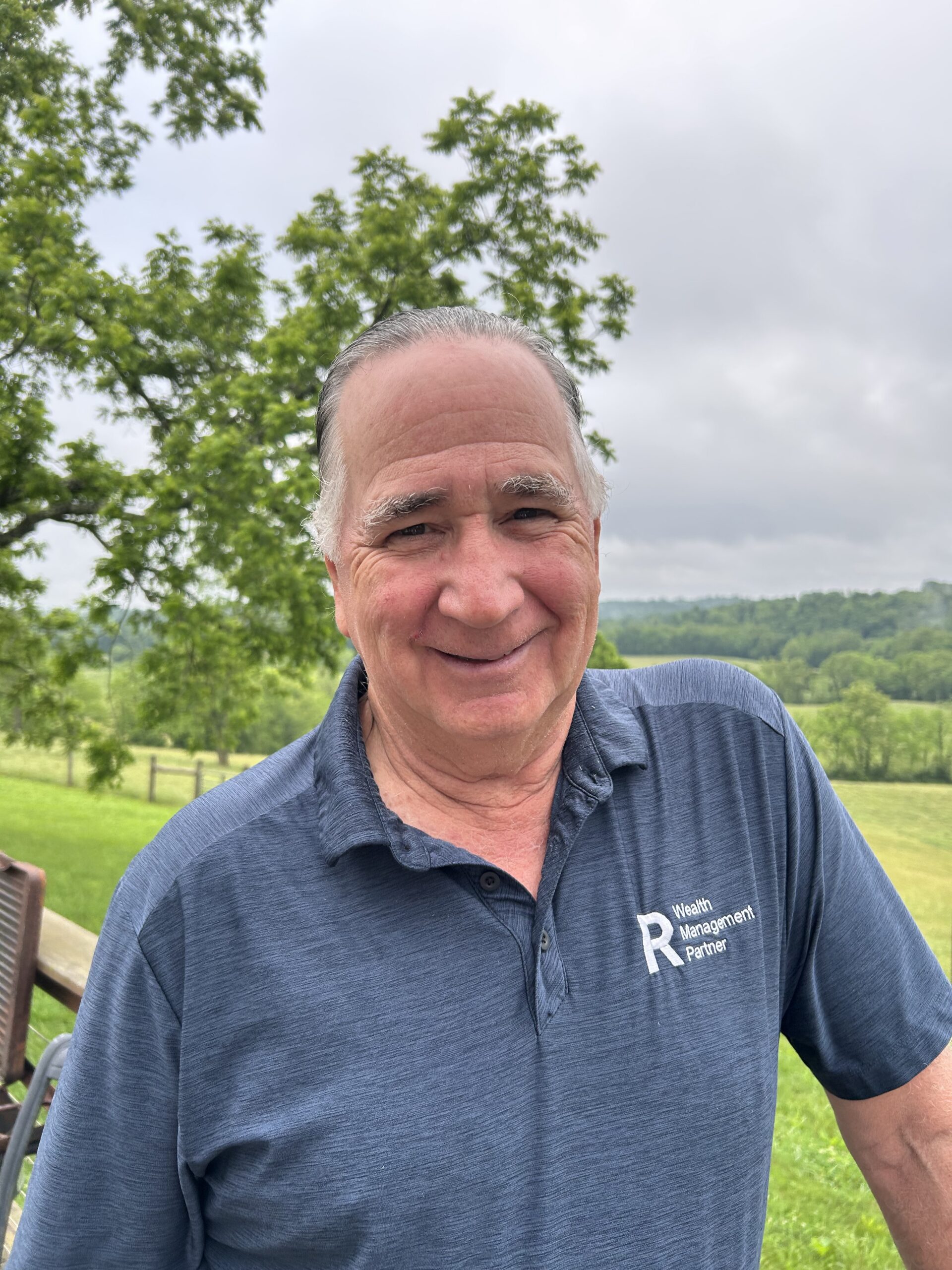 Carter Randolph, owner of Randolph Farm, photographed outdoors with green hills behind him.